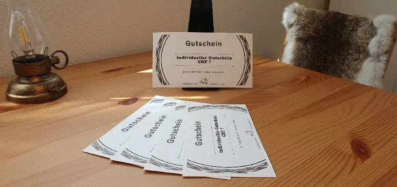 Ein Holztisch mit 5 Gutscheinen drauf